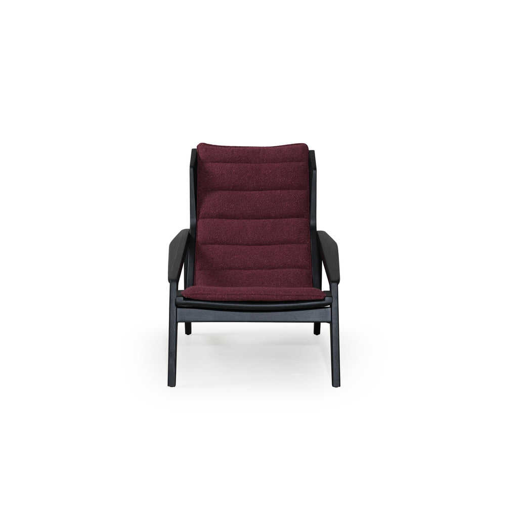 Modern lounge chair with black frame and deep burgundy upholstered cushions. Features angled legs, continuous backrest, and integrated armrests. Fabric has textured surface. Designed for seated relaxation. Category: Furniture > Chairs > Lounge Chairs