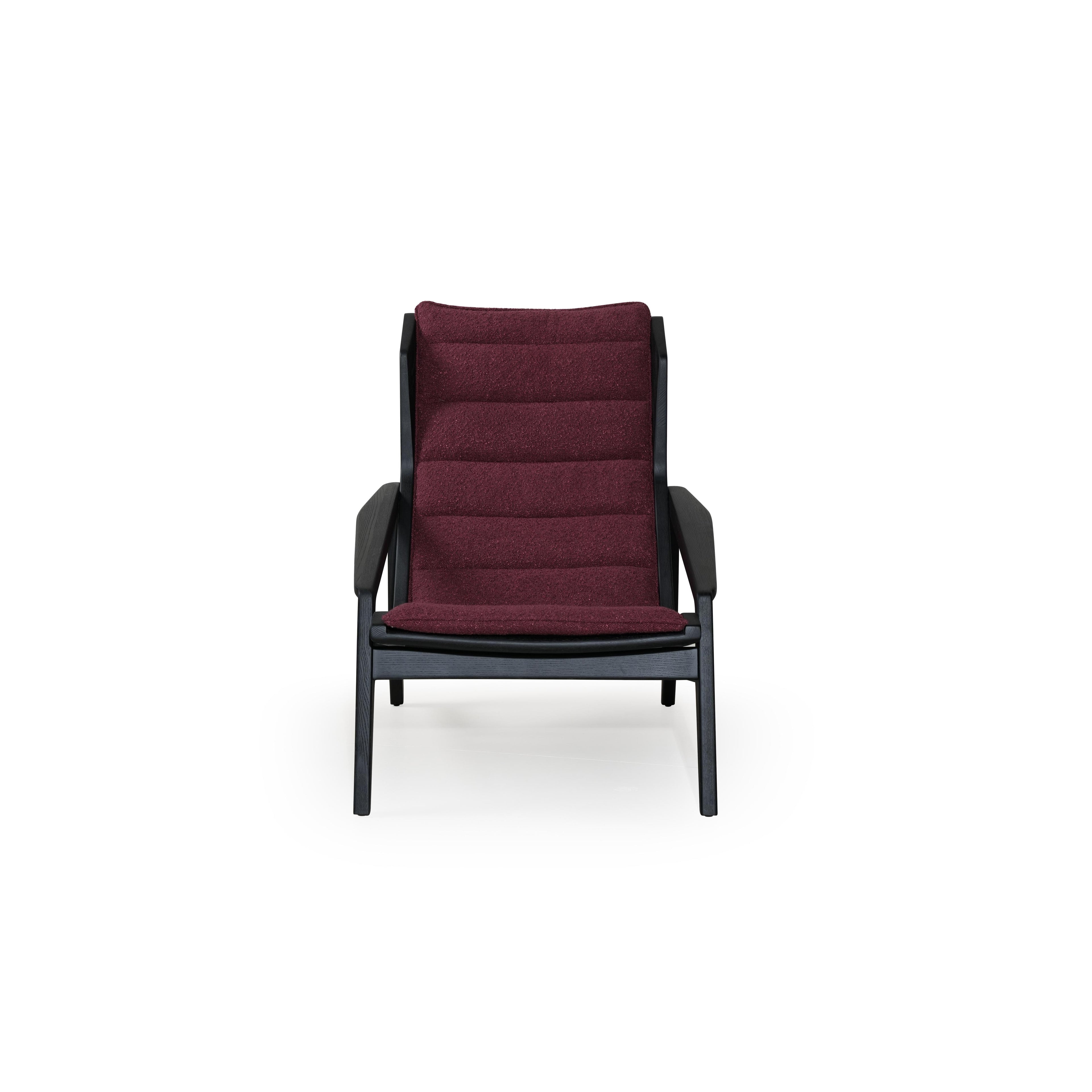 Modern lounge chair with black frame and deep burgundy upholstered cushions. Features angled legs, continuous backrest, and integrated armrests. Fabric has textured surface. Designed for seated relaxation. Category: Furniture > Chairs > Lounge Chairs