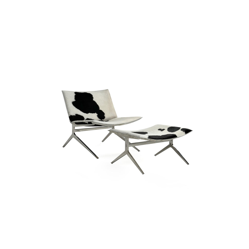 This is a modern lounge chair with a black and white cowhide upholstery on the seat and backrest, supported by a sleek, metallic X-shaped base. The chair has no arms or cushions, and its structure is minimalist. Intended for casual seating, it features a flat, continuous surface for comfort. Category: Furniture > Chairs > Lounge Chairs