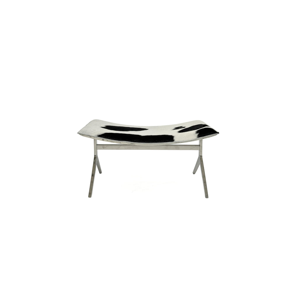 This is a modern lounge chair with a black and white cowhide upholstery on the seat and backrest, supported by a sleek, metallic X-shaped base. The chair has no arms or cushions, and its structure is minimalist. Intended for casual seating, it features a flat, continuous surface for comfort. Category: Furniture > Chairs > Lounge Chairs