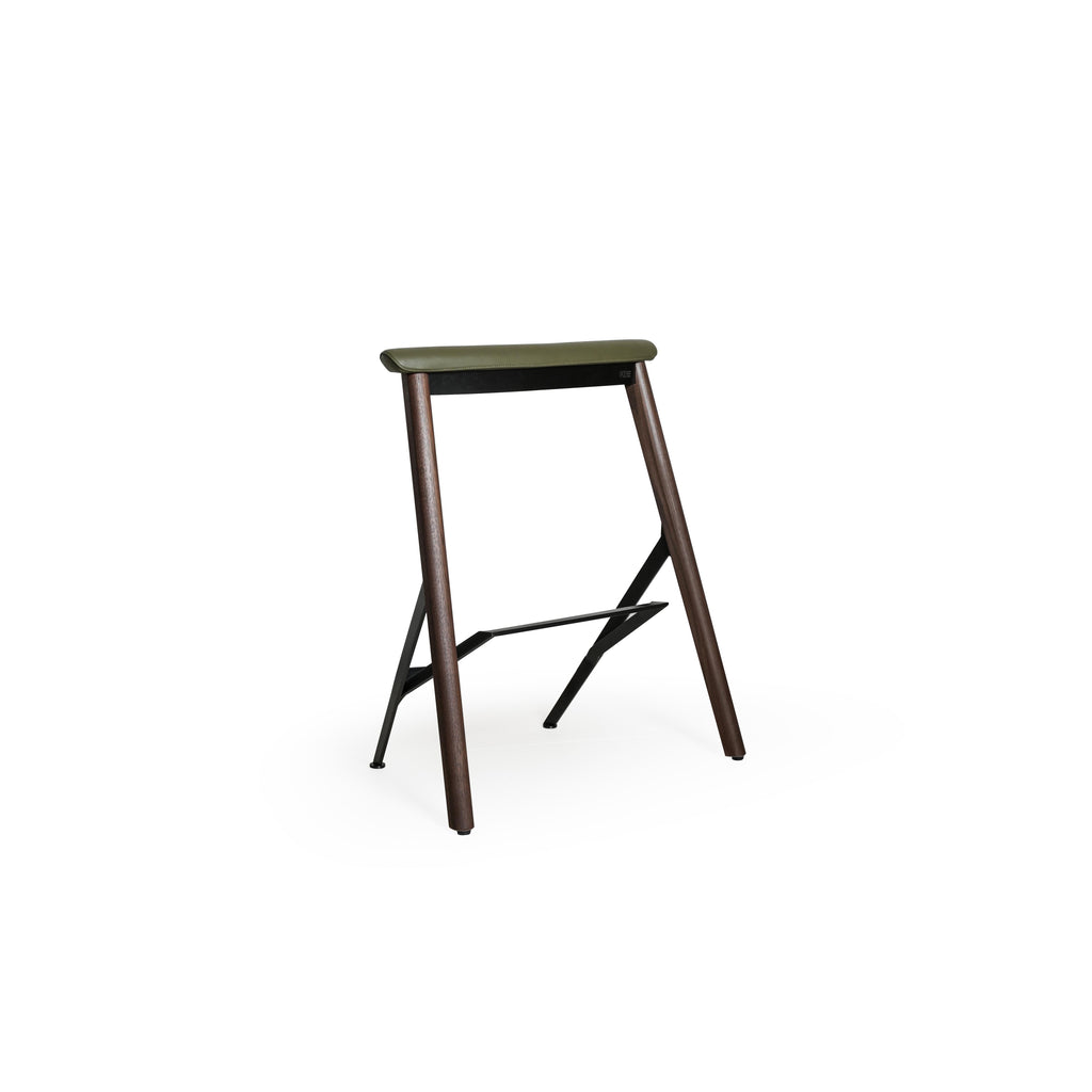 This is a bar stool with an olive green upholstered seat, dark wood legs, and a metal frame with a footrest. The seat has visible stitching. It’s designed for sitting at counters or tables. Category: furniture/stools