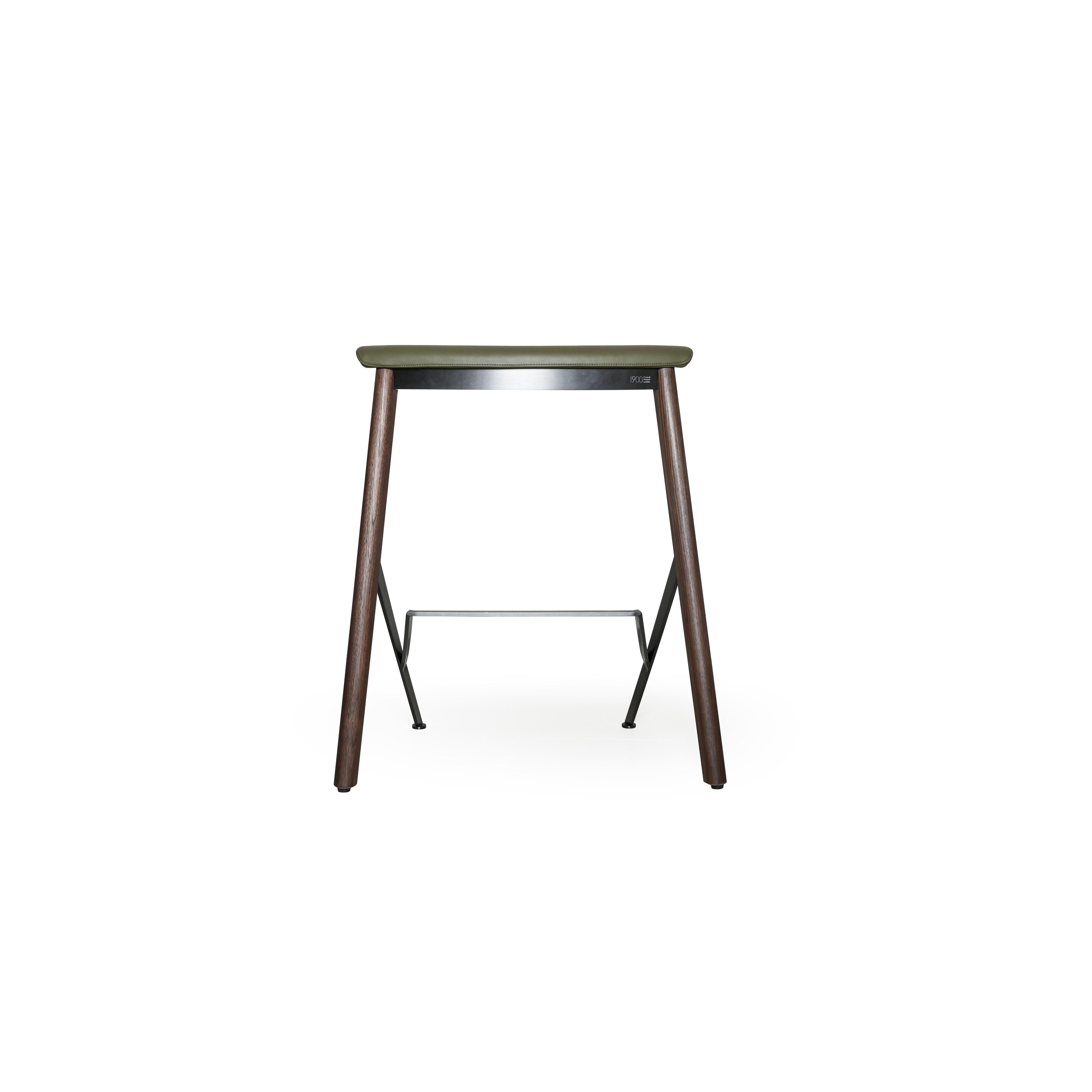 This is a bar stool with an olive green upholstered seat, dark wood legs, and a metal frame with a footrest. The seat has visible stitching. It’s designed for sitting at counters or tables. Category: furniture/stools