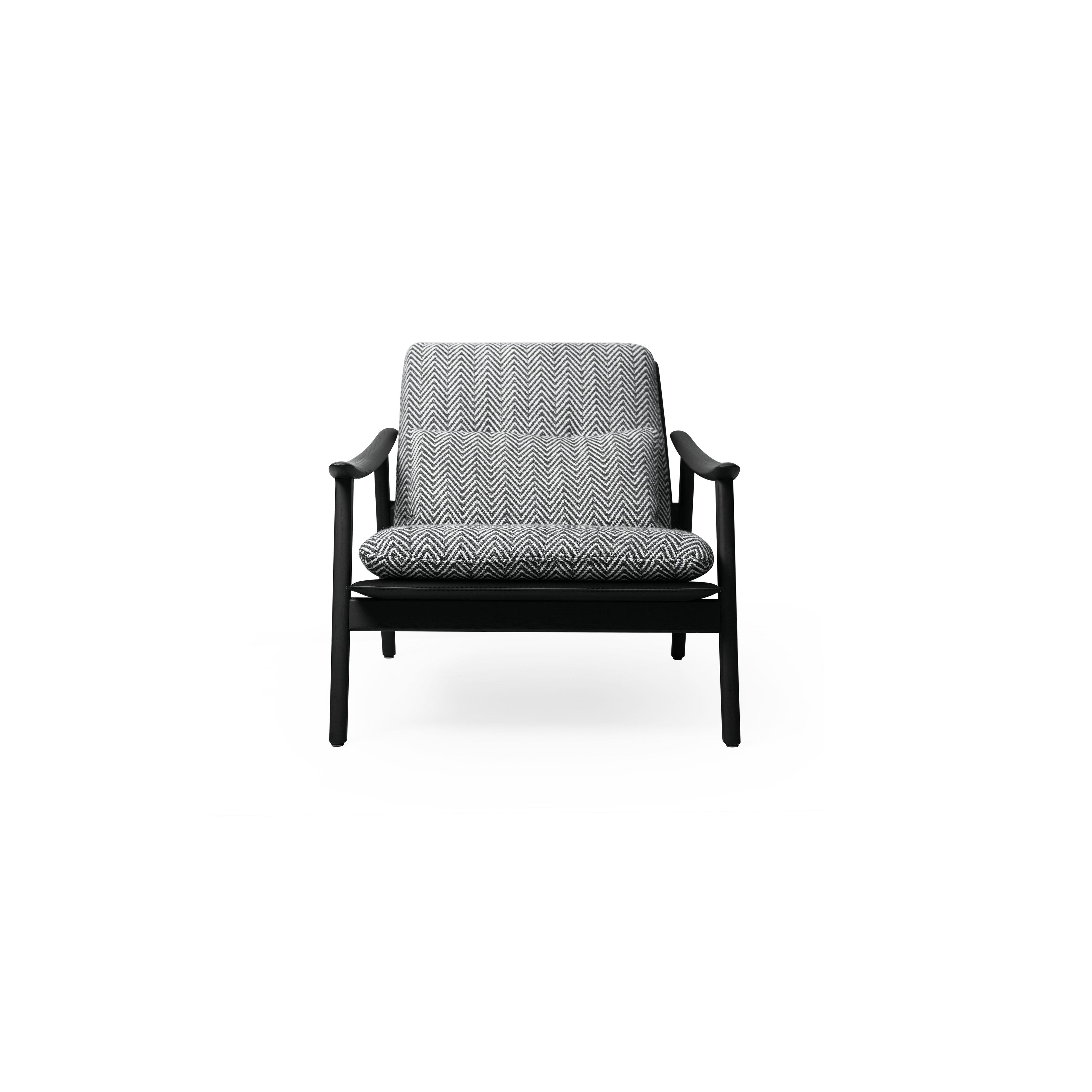 A single armchair with a black frame and herringbone-patterned fabric upholstery. It features curved arms, four angled legs, a cushioned seat and backrest, and visible stitching. Designed for seating, it has a modern silhouette with a low-profile base. Category: Furniture > Chairs > Armchairs
