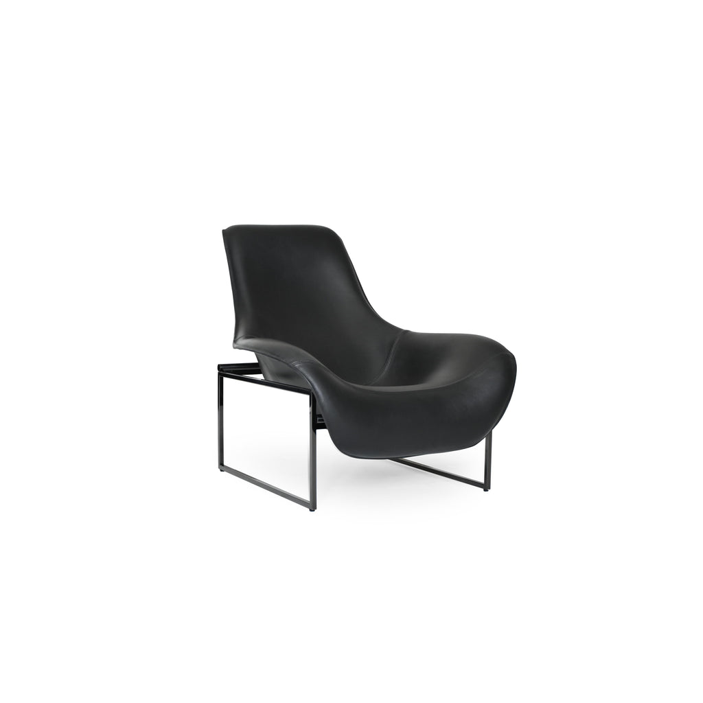 Black leather-like upholstered armchair with curved backrest and integrated armrests, supported by slender metal legs; minimalist form designed for seated comfort in living or reading spaces. Category: furniture/chairs/armchairs