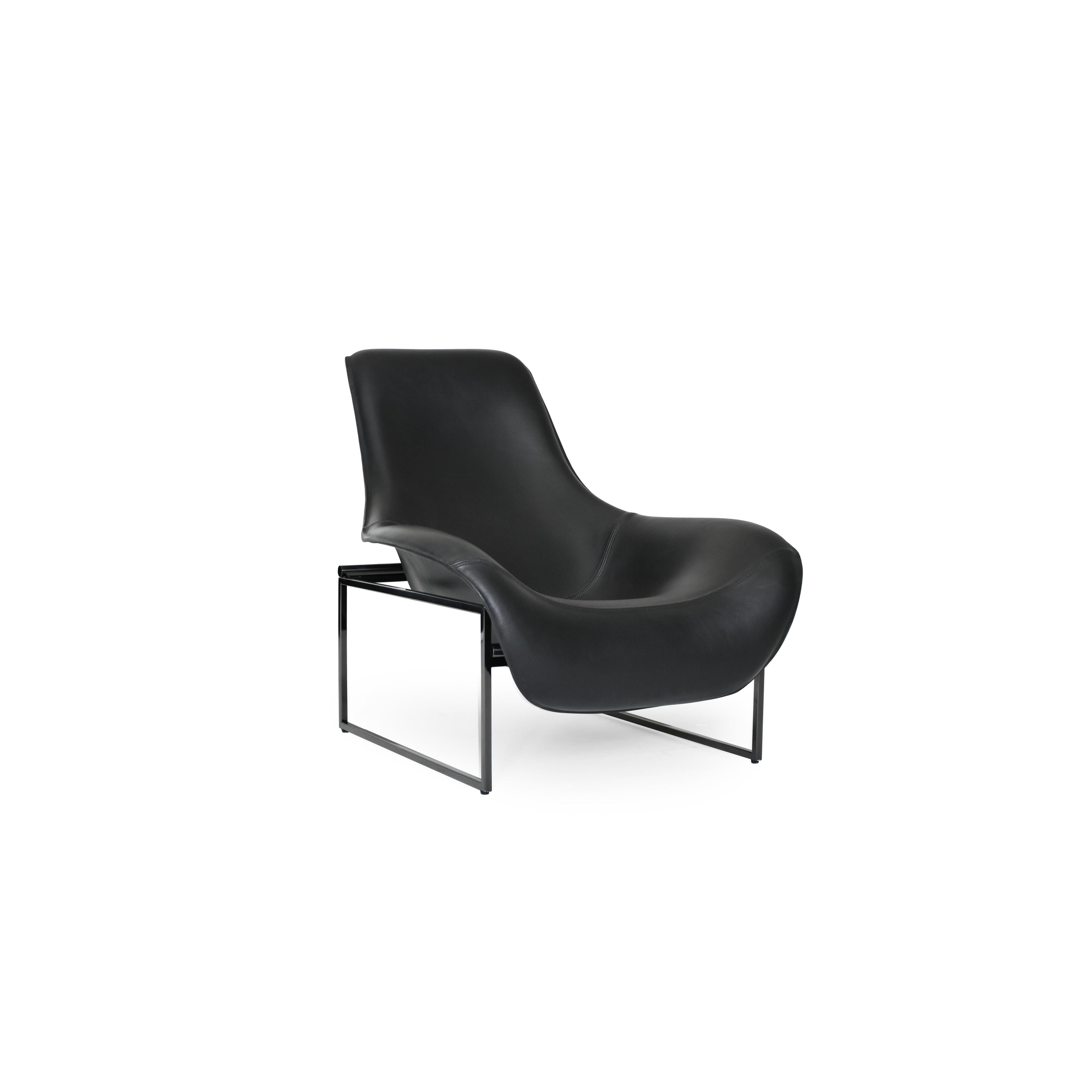 Black leather-like upholstered armchair with curved backrest and integrated armrests, supported by slender metal legs; minimalist form designed for seated comfort in living or reading spaces. Category: furniture/chairs/armchairs