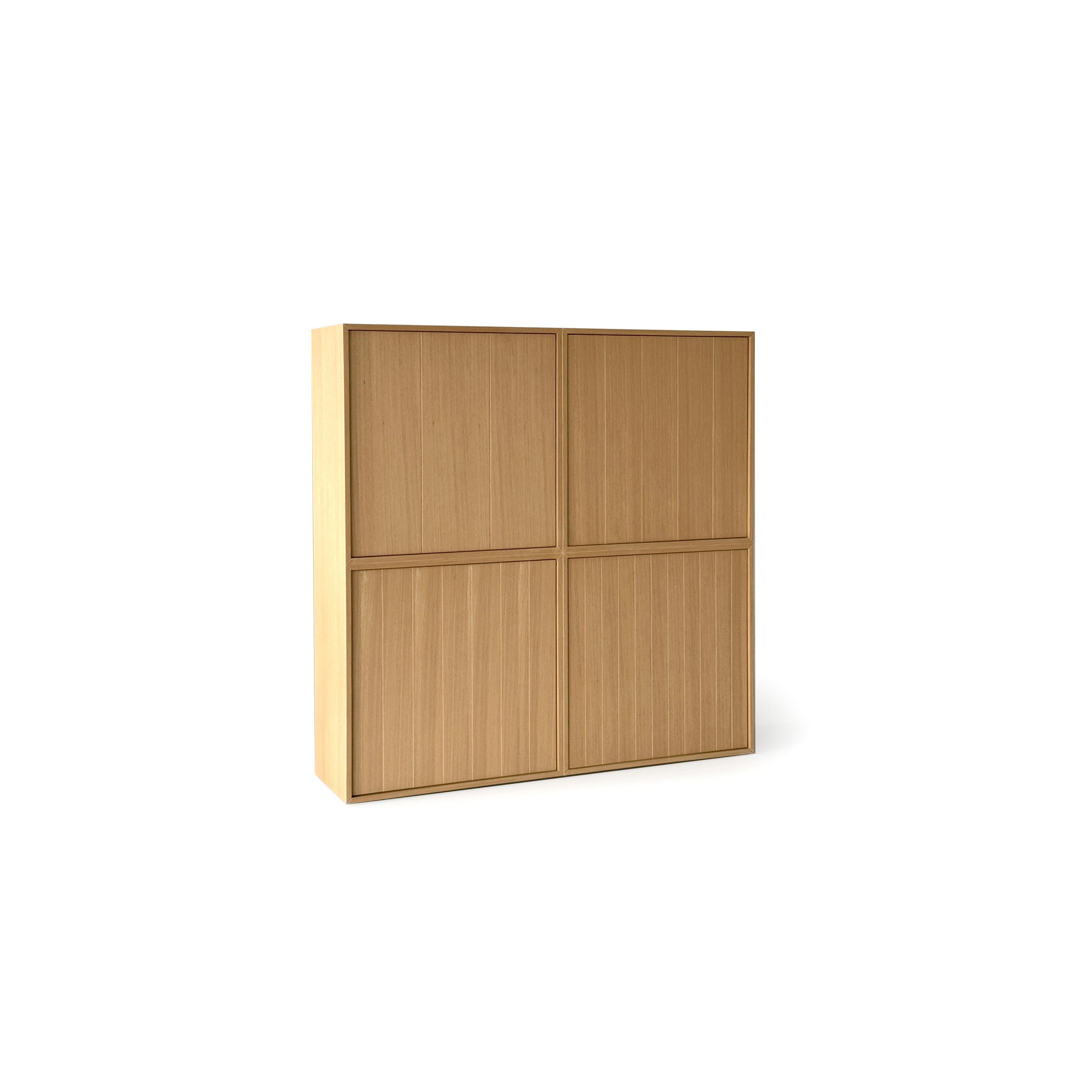 This is a four-door storage cabinet with a light wood finish and vertical grain texture. It has a rectangular form with two doors on each of two vertical sections. The doors are flush with the frame and have no visible handles or fasteners. Intended for general storage, it features a clean, minimalist design. Category: furniture > storage > cabinets