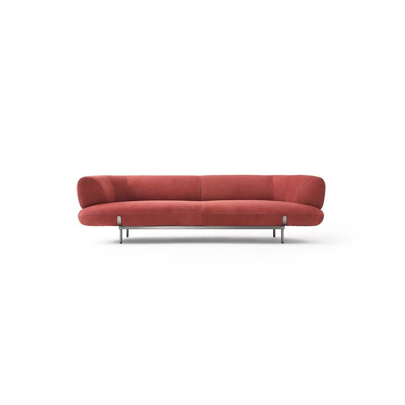 Red upholstered sofa with curved backrest and seat cushions, supported by four slender metal legs; fabric surface shows subtle texture; designed for seating; Category: Furniture > Sofas > Sectionals
