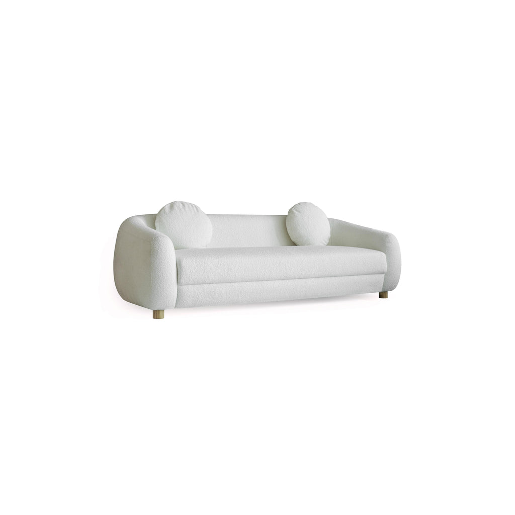 This is a three-seater sofa with rounded arms and a low back, upholstered in a beige, textured fabric. It rests on four small, rounded wooden legs. Designed for seating, it features a continuous cushioned seat and backrest with no visible stitching or fasteners. Category: Furniture > Sofas > Sectionals