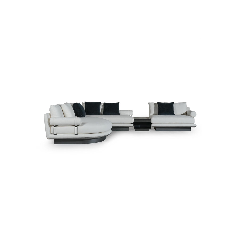 Modern sectional sofa with white upholstered cushions and dark navy throw pillows; L-shaped configuration with rounded arms, low-profile black base, and visible metal frame supports; designed for seating and lounging; Category: furniture > sofas > sectional sofas