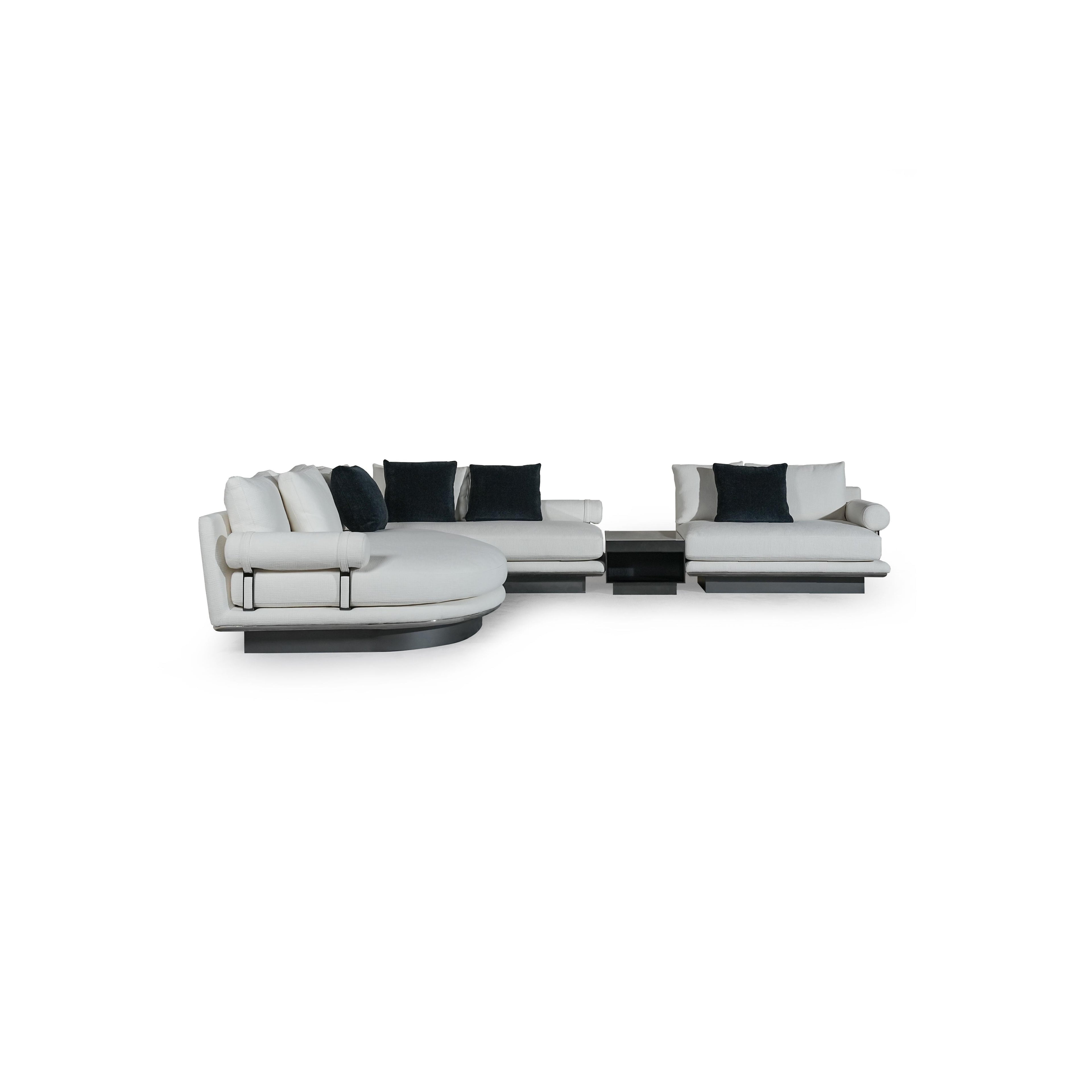 Modern sectional sofa with white upholstered cushions and dark navy throw pillows; L-shaped configuration with rounded arms, low-profile black base, and visible metal frame supports; designed for seating and lounging; Category: furniture > sofas > sectional sofas