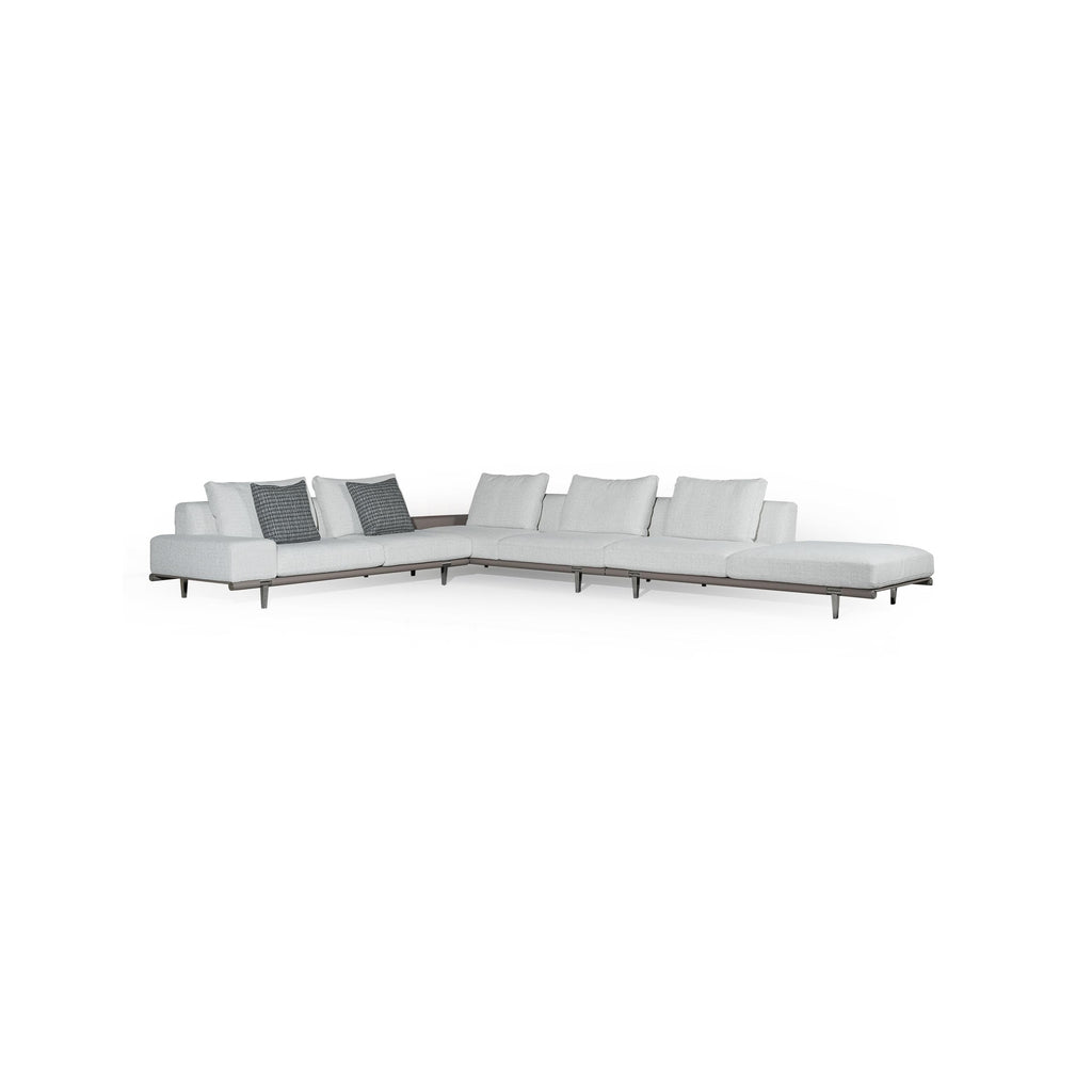 Modern sectional sofa with light gray fabric upholstery, low-profile metal legs, segmented backrest and seat cushions, and two dark patterned throw pillows; designed for lounging and seating in open spaces. Category: furniture/sofas