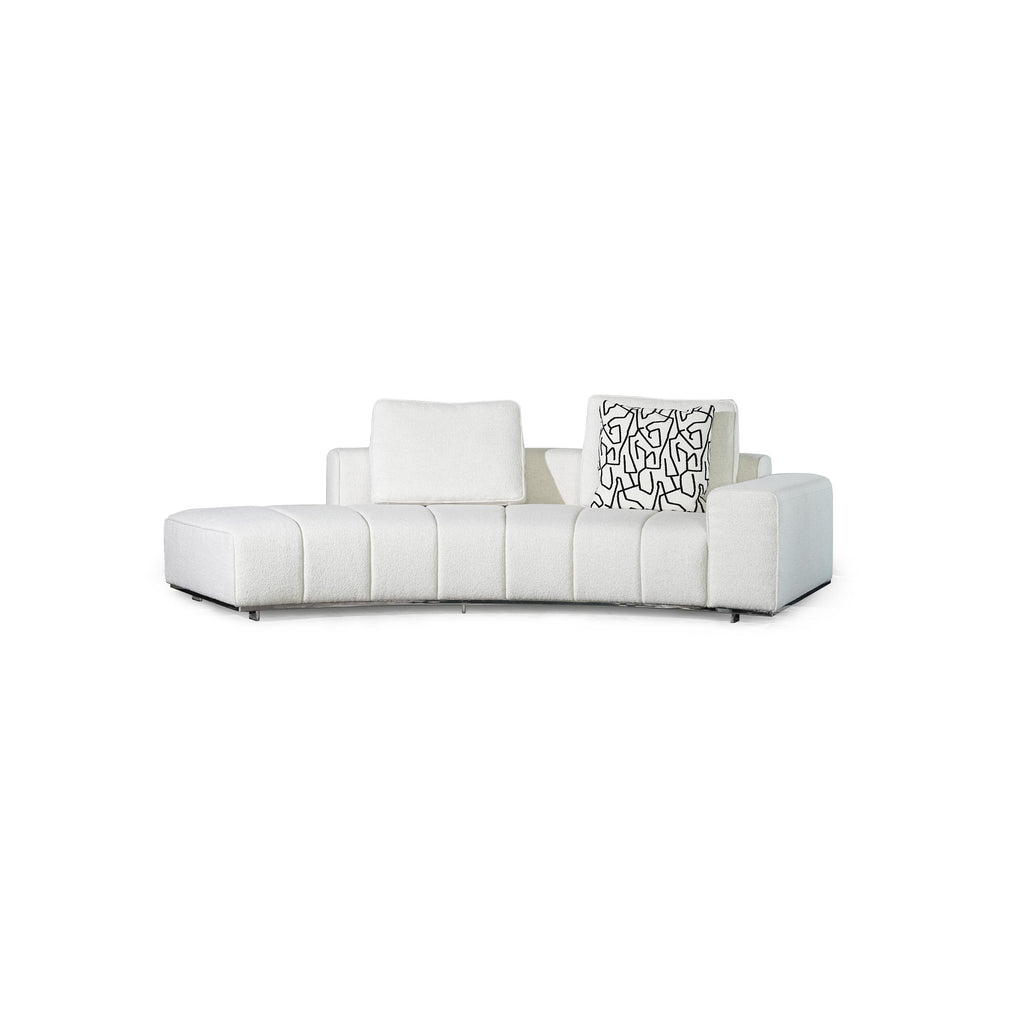 Black leather-like sectional sofa with curved form, featuring segmented cushioning, two patterned throw pillows, and low-profile metal legs; designed for seating and lounging, with visible stitching and defined armrests. Category: furniture/seating/sofas