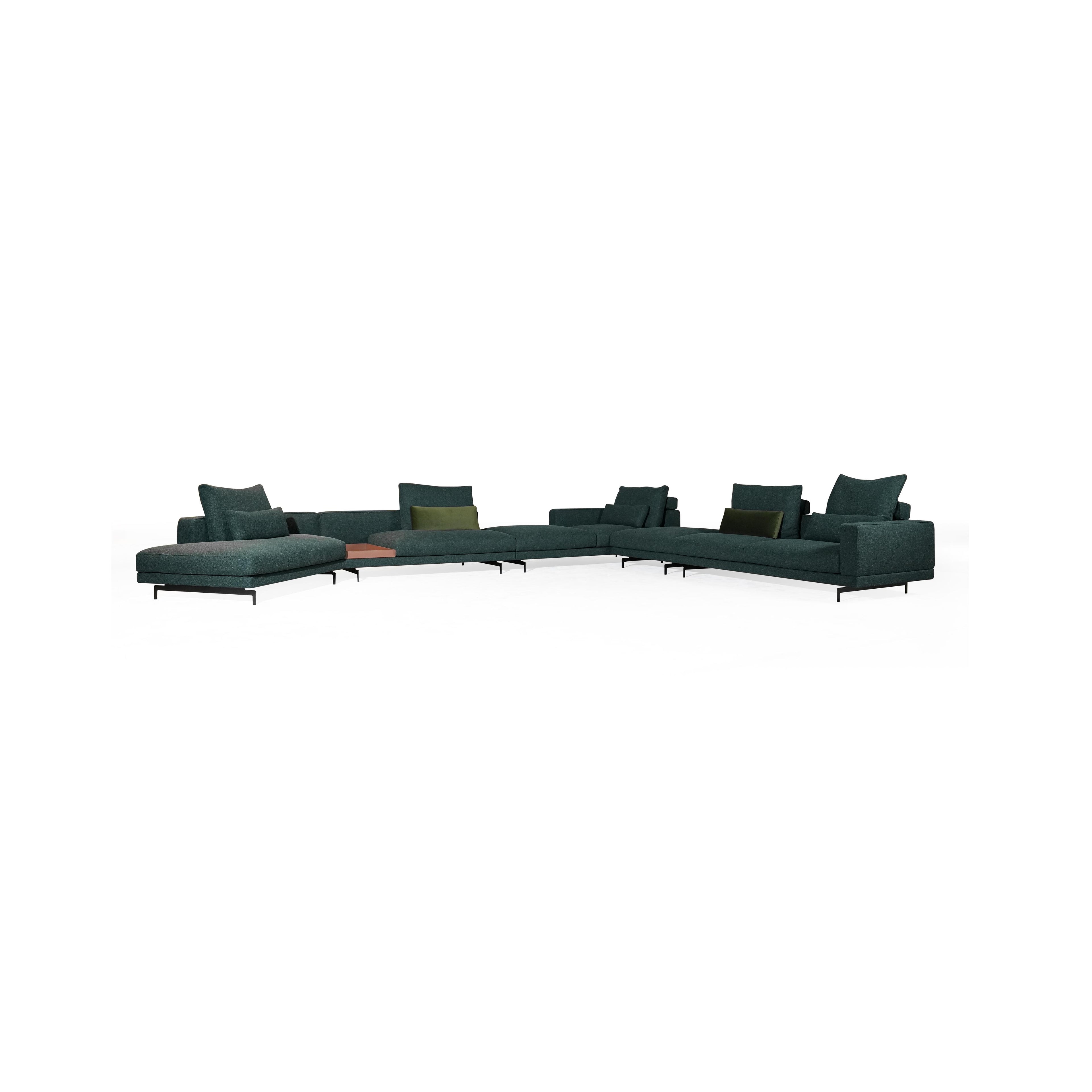 Modular sectional sofa with dark teal fabric upholstery, low-profile black metal legs, segmented backrests and armrests, and multiple cushioned seating sections; includes olive and dark green accent pillows; designed for lounging and casual seating arrangements. Category: furniture/sofas