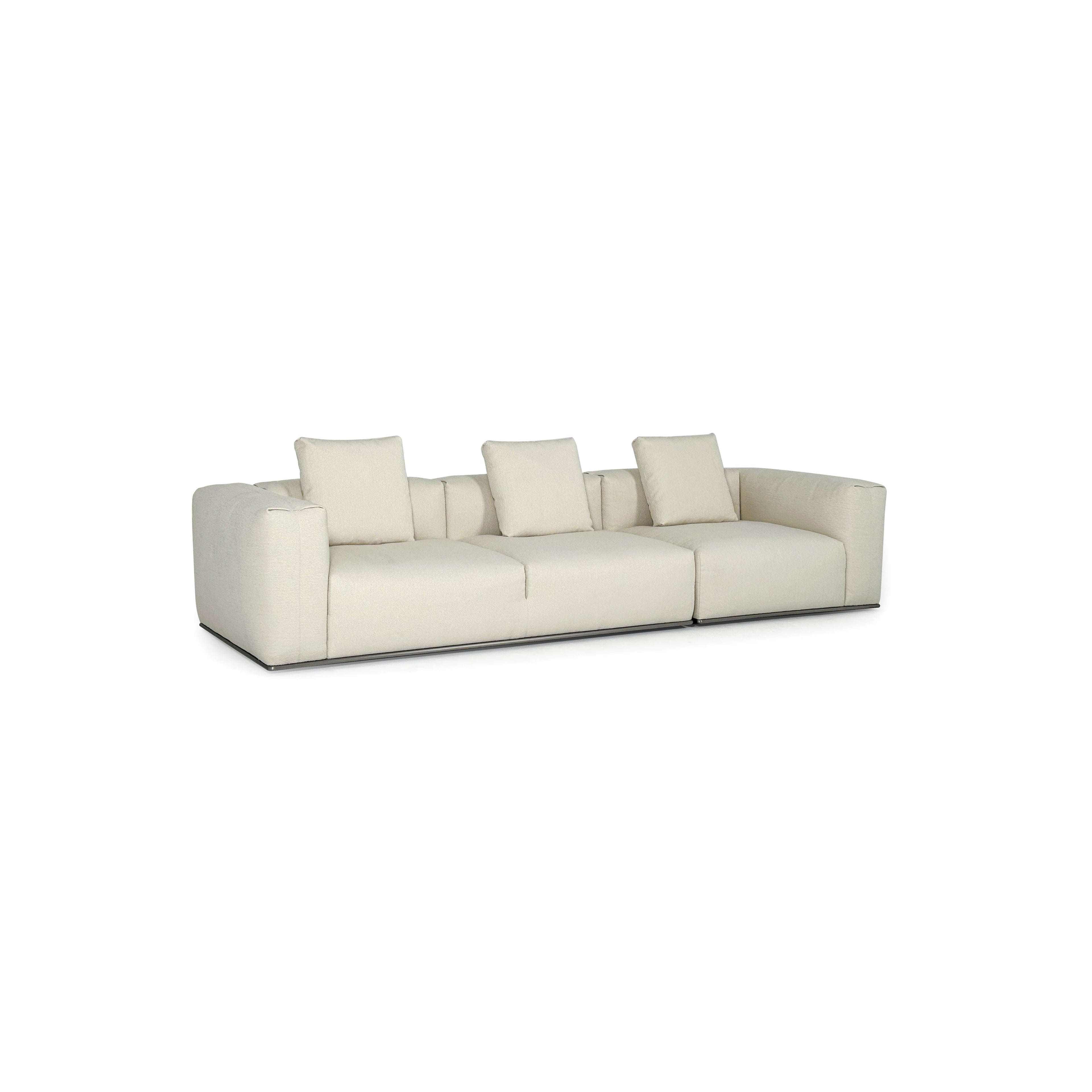 A three-seater sofa with off-white fabric upholstery, featuring segmented cushions, squared arms, and a low-profile metal base. It includes three matching back cushions. Designed for seating, it has a clean, modular form with visible stitching and no visible fasteners or handles. Category: Furniture > Sofas > Sectionals