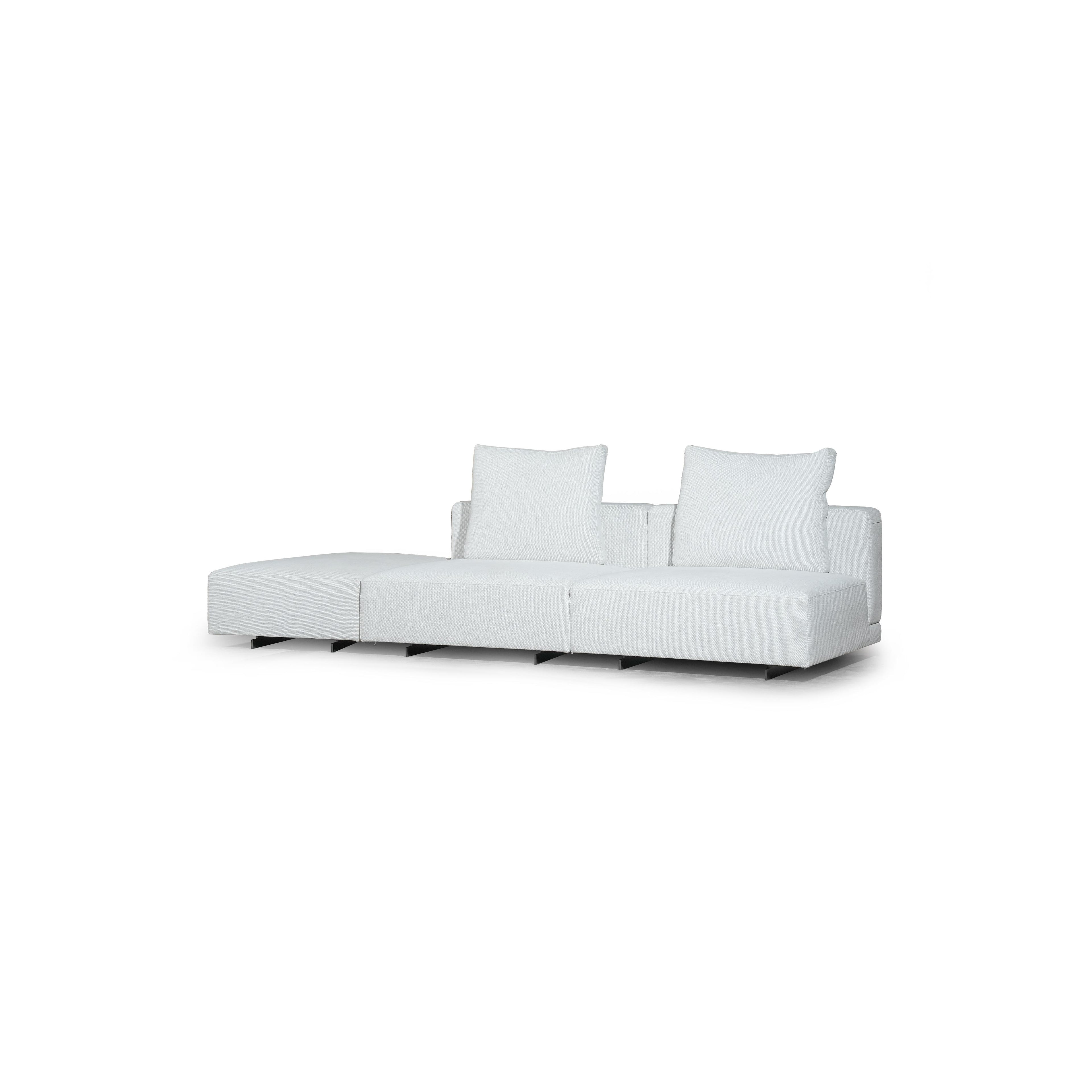 Brown leather-like sofa with three rectangular seat sections, two armrests, and two back cushions. Each section has a matching cushion. Right end features a wooden and dark gray panel. Supported by black legs. Intended for seating. Category: furniture/sofas