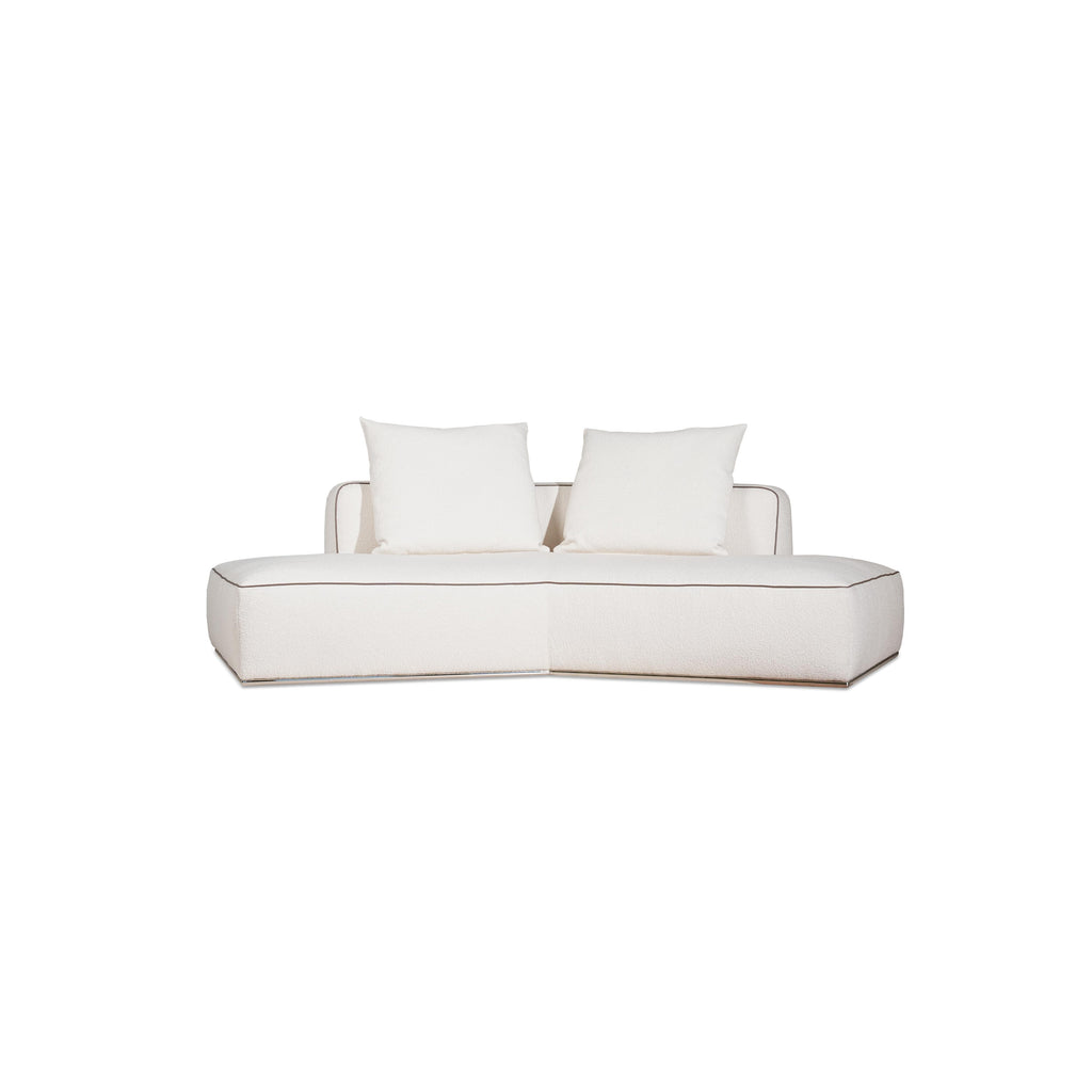 This is a modular sectional sofa with a low-profile, L-shaped form. It features white fabric upholstery with contrasting dark red accent pillows. The sofa has defined armrests, segmented cushioning, and visible stitching along edges. Designed for seating, it includes multiple cushioned sections for comfort. Category: furniture/sofas