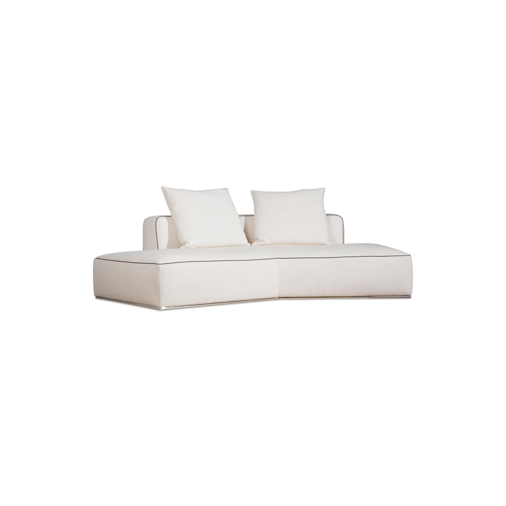 This is a modular sectional sofa with a low-profile, L-shaped form. It features white fabric upholstery with contrasting dark red accent pillows. The sofa has defined armrests, segmented cushioning, and visible stitching along edges. Designed for seating, it includes multiple cushioned sections for comfort. Category: furniture/sofas