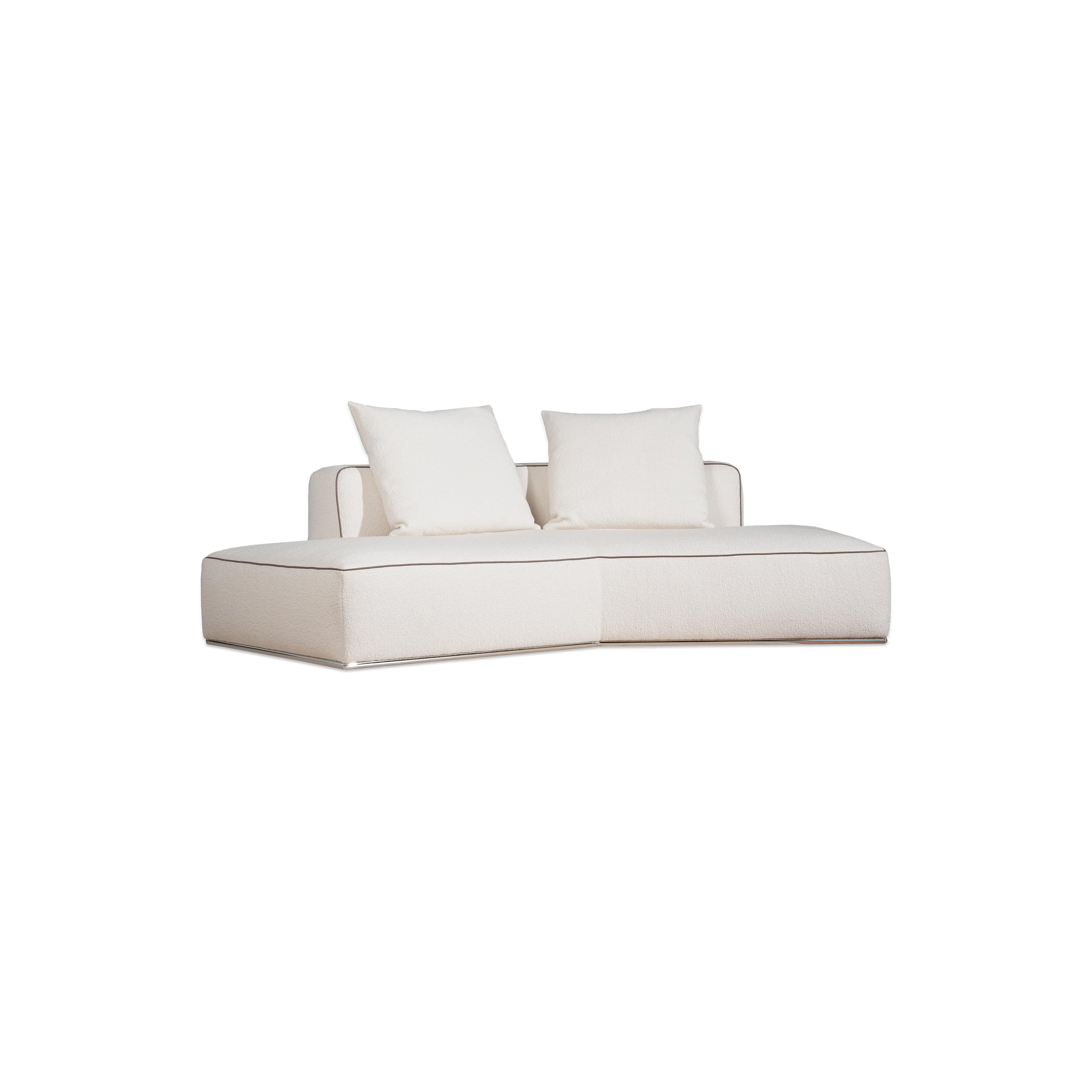 This is a modular sectional sofa with a low-profile, L-shaped form. It features white fabric upholstery with contrasting dark red accent pillows. The sofa has defined armrests, segmented cushioning, and visible stitching along edges. Designed for seating, it includes multiple cushioned sections for comfort. Category: furniture/sofas