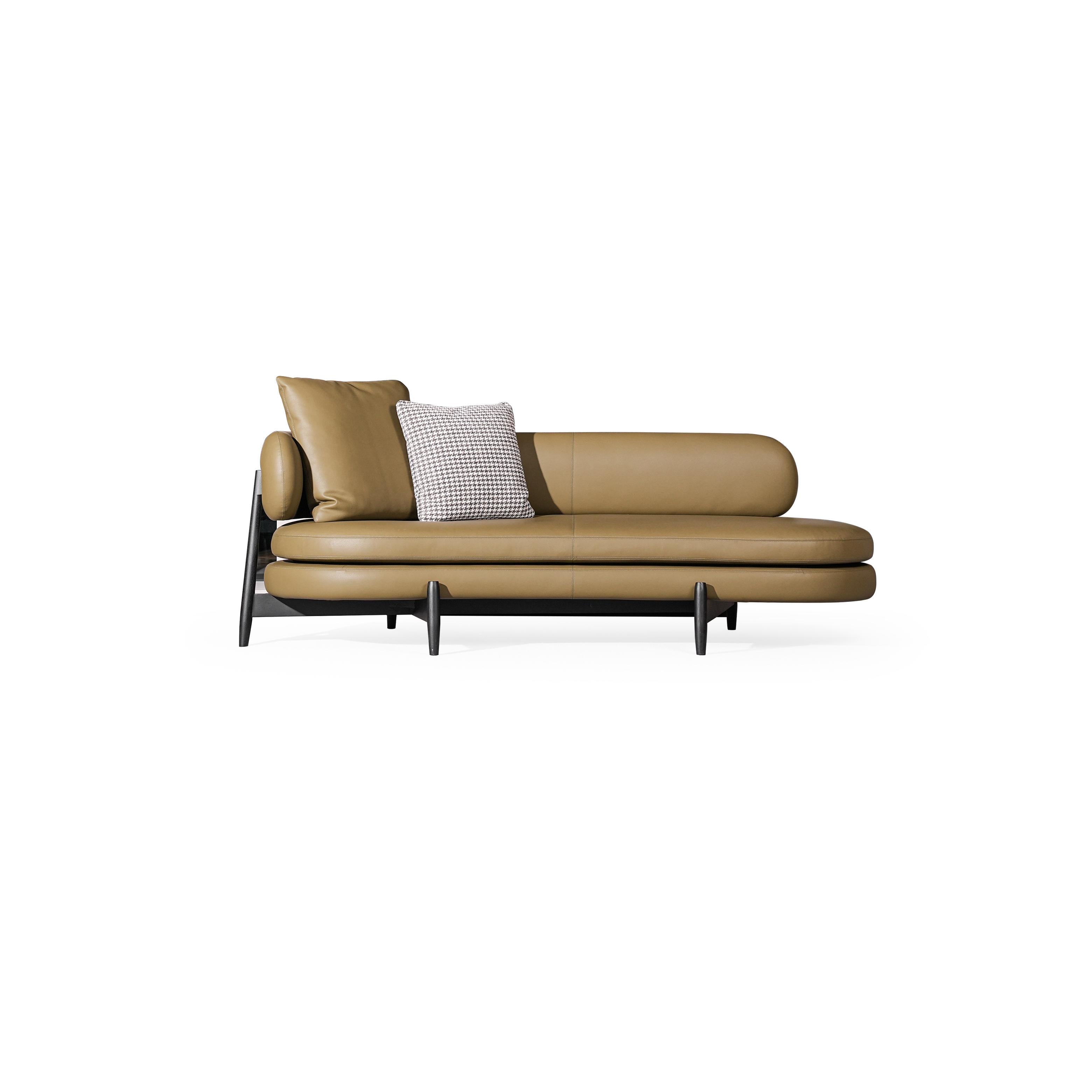Tan leather-like upholstered chaise lounge with rounded backrest and armrests, supported by dark metal legs; features two cushions, one with houndstooth pattern, stitched seams; designed for reclining or lounging. Category: furniture/chairs-and-sofas/chaises-longues