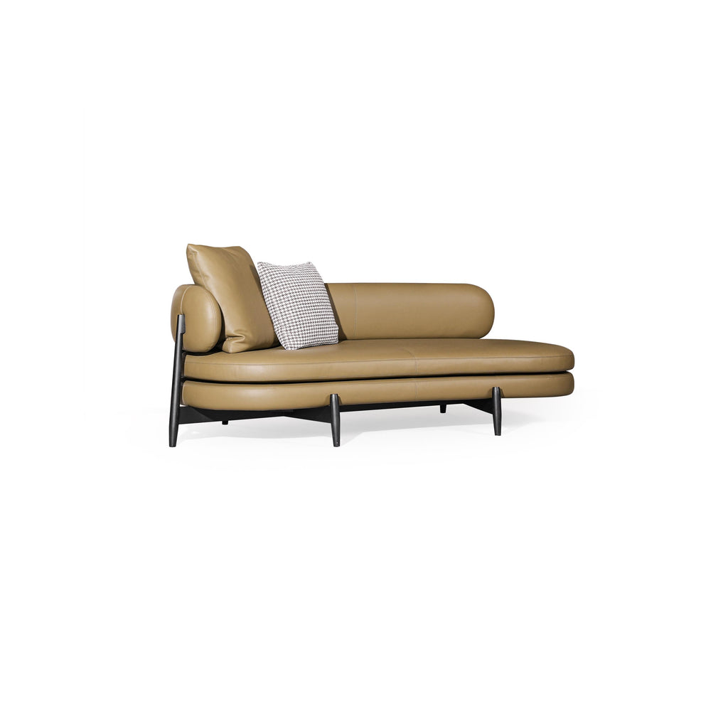 Tan leather-like upholstered chaise lounge with rounded backrest and armrests, supported by dark metal legs; features two cushions, one with houndstooth pattern, stitched seams; designed for reclining or lounging. Category: furniture/chairs-and-sofas/chaises-longues