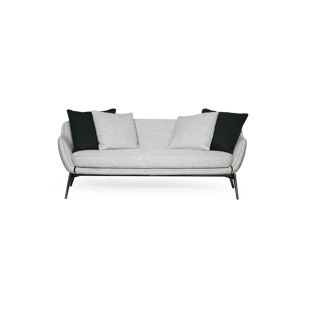 A two-seater sofa with light gray fabric upholstery and black accent pillows, featuring curved armrests, a low-profile backrest, and thin black metal legs. The seat and back cushions are visibly padded with matching fabric. Category: furniture/soups/sofas