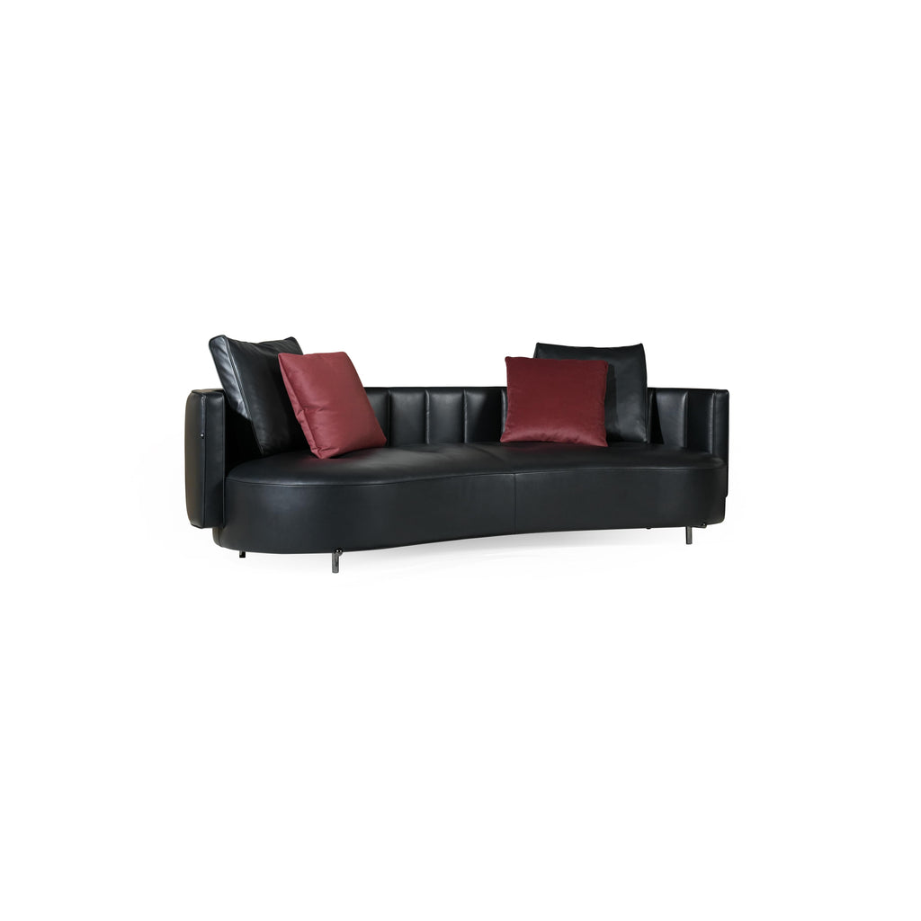 Black leather-like sofa with curved seat and back, featuring two red velvet cushions and two black back cushions; supported by four thin metal legs; designed for seating; Category: Furniture > Sofas > Sectionals