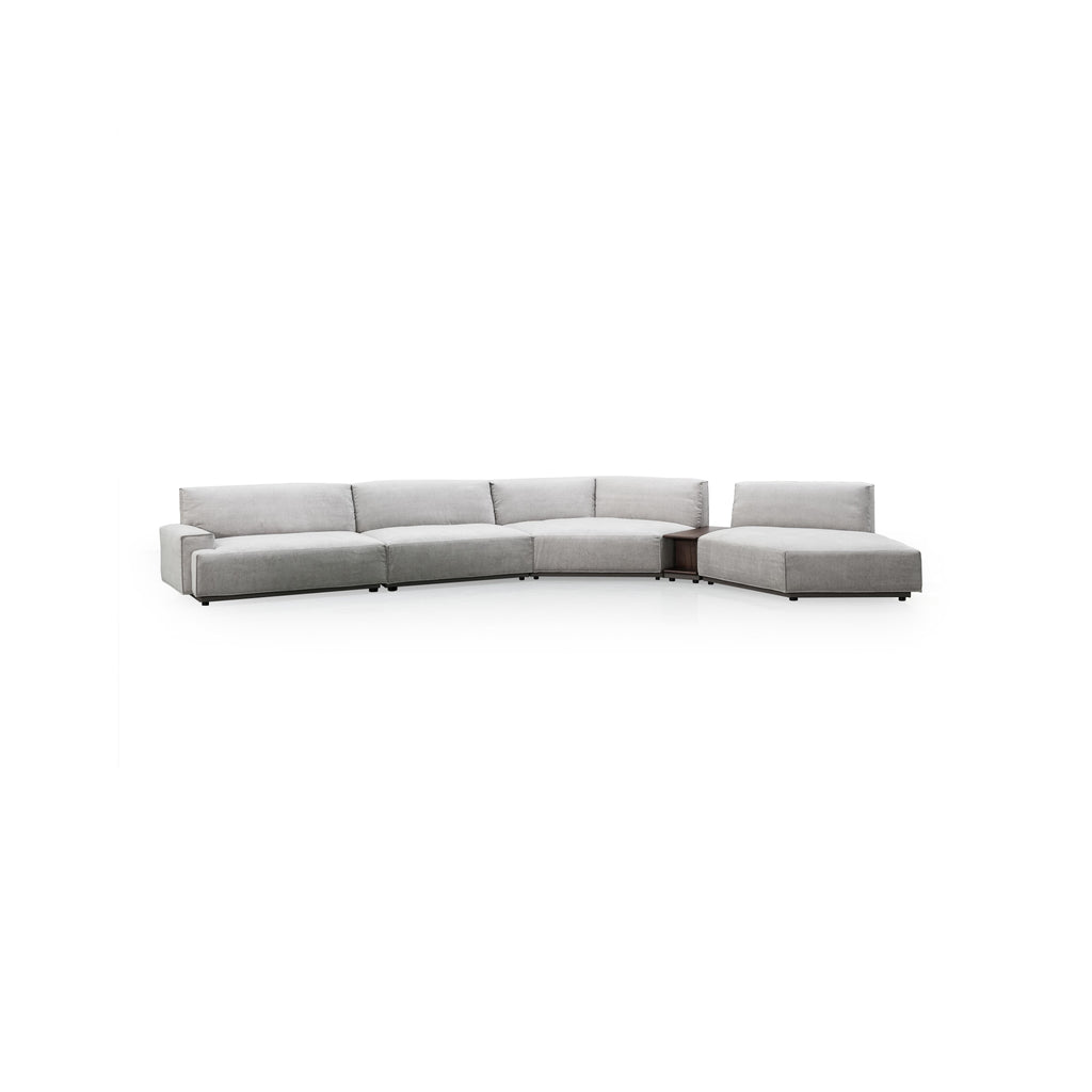 This is a sectional sofa with a light gray fabric upholstery, featuring a curved L-shape with multiple cushioned sections, low-profile black legs, and integrated armrests and backrests. It includes a built-in side table with a visible open compartment. Intended for seating and casual lounging. Category: furniture/sofas