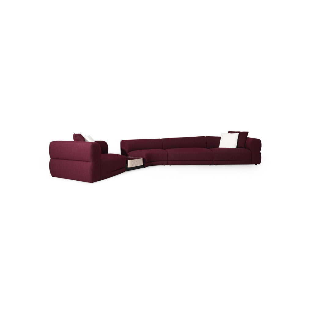 This is a modular sectional sofa with deep burgundy fabric upholstery, featuring curved backrests, padded armrests, and low-profile legs. It includes a chaise lounge section with integrated storage and white throw pillows. Designed for seating and lounging, it has visible seams and cushioned surfaces. Category: furniture/sofas