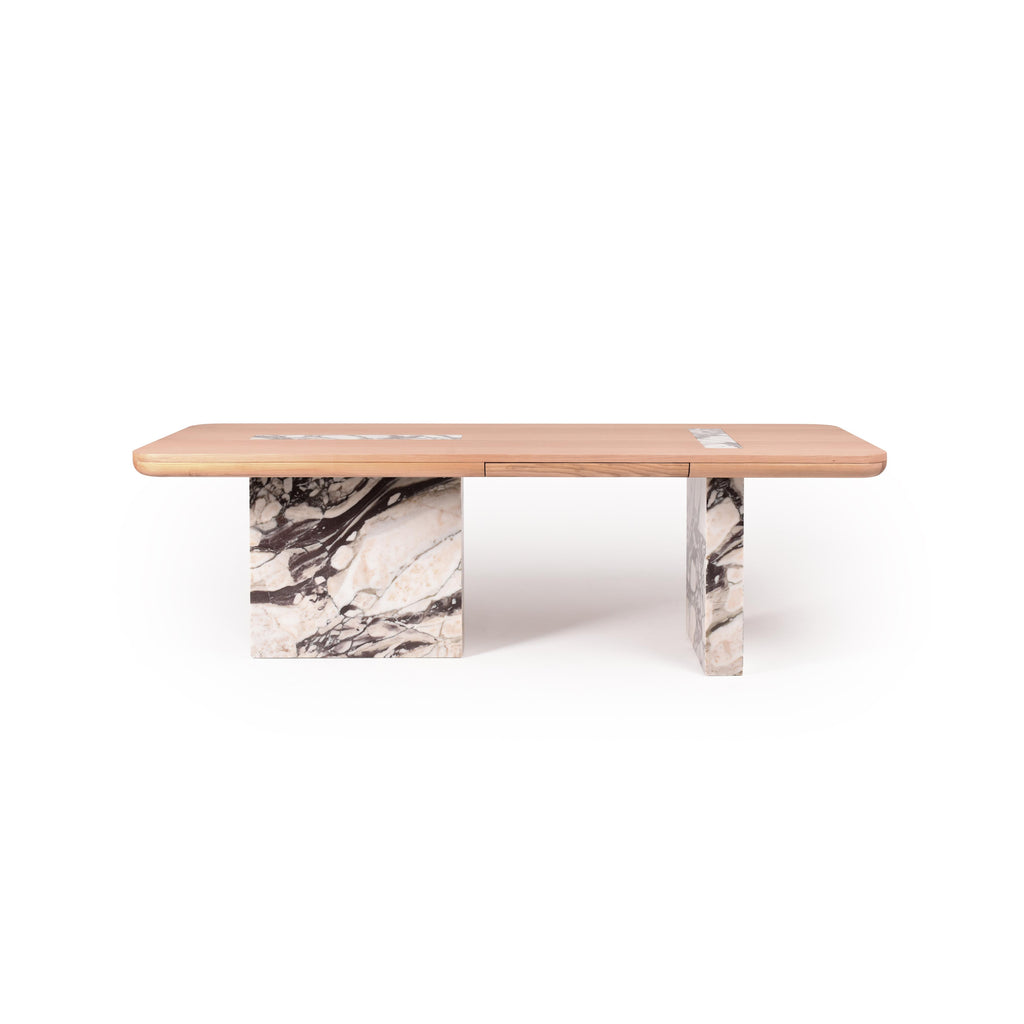 Rectangular dining table with light wood top and two thick marble legs featuring white and dark veining. Table has a central seam dividing the top. Intended for dining or workspace use. Category: furniture/dining-tables