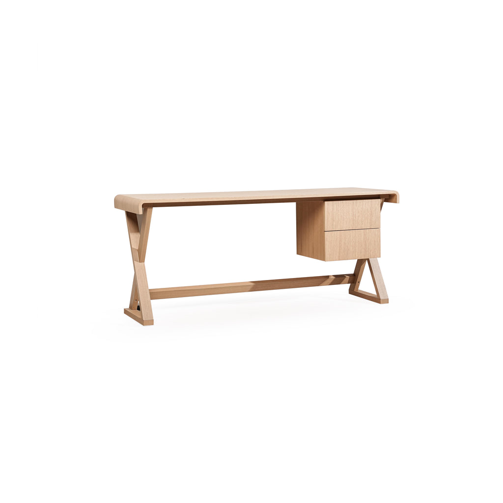 A wooden desk with a light-toned finish, featuring a rectangular top, two drawers on the right, and angled legs connected by a horizontal support beam. The surface shows visible wood grain. Intended for work or study use. Category: furniture/desks