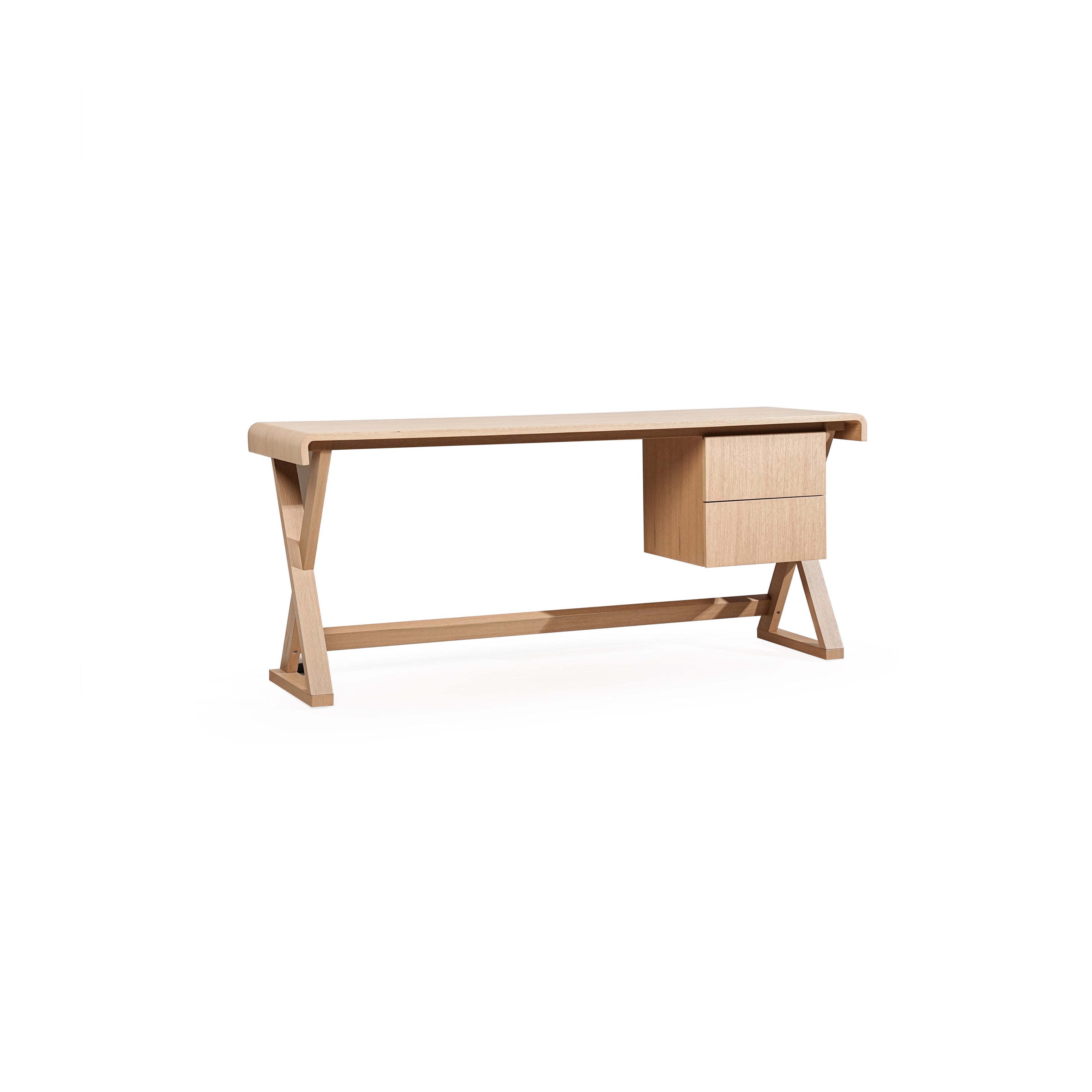 A wooden desk with a light-toned finish, featuring a rectangular top, two drawers on the right, and angled legs connected by a horizontal support beam. The surface shows visible wood grain. Intended for work or study use. Category: furniture/desks