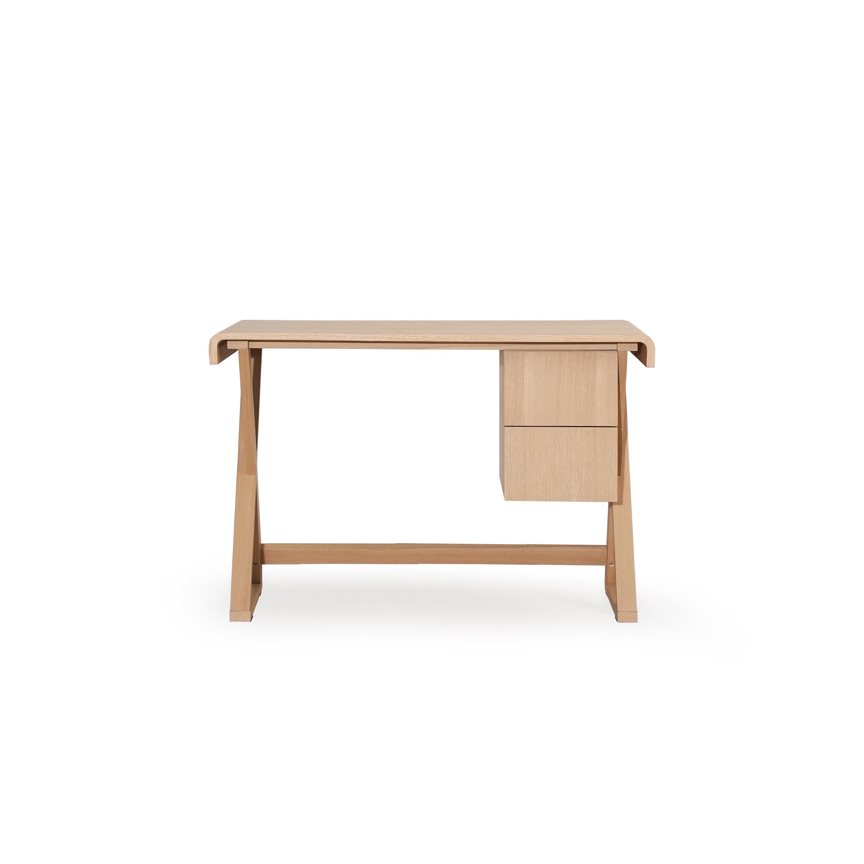 A wooden desk with a light-toned finish, featuring a rectangular top, two drawers on the right, and angled legs connected by a horizontal support beam. The surface shows visible wood grain. Intended for work or study use. Category: furniture/desks