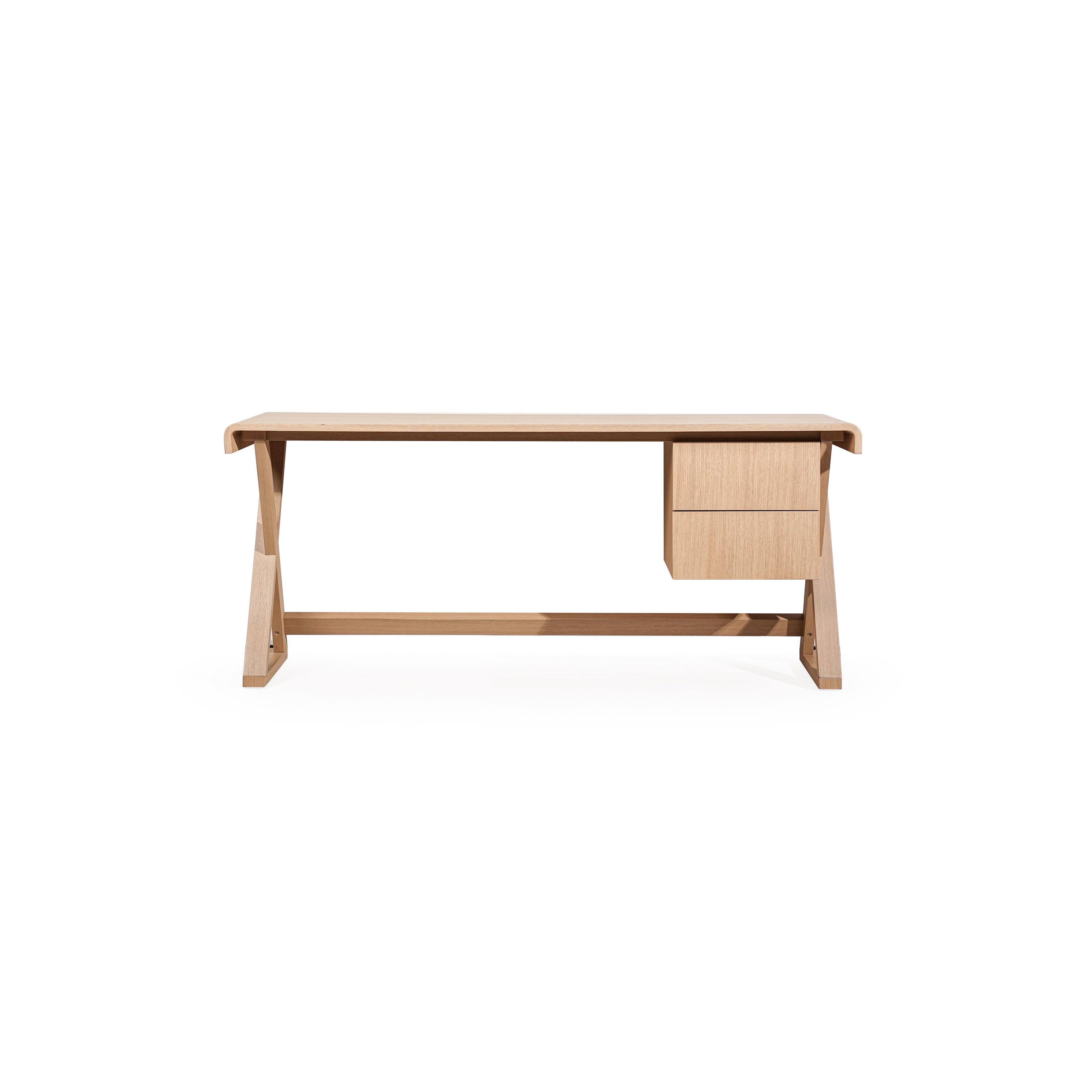 A wooden desk with a light-toned finish, featuring a rectangular top, two drawers on the right, and angled legs connected by a horizontal support beam. The surface shows visible wood grain. Intended for work or study use. Category: furniture/desks