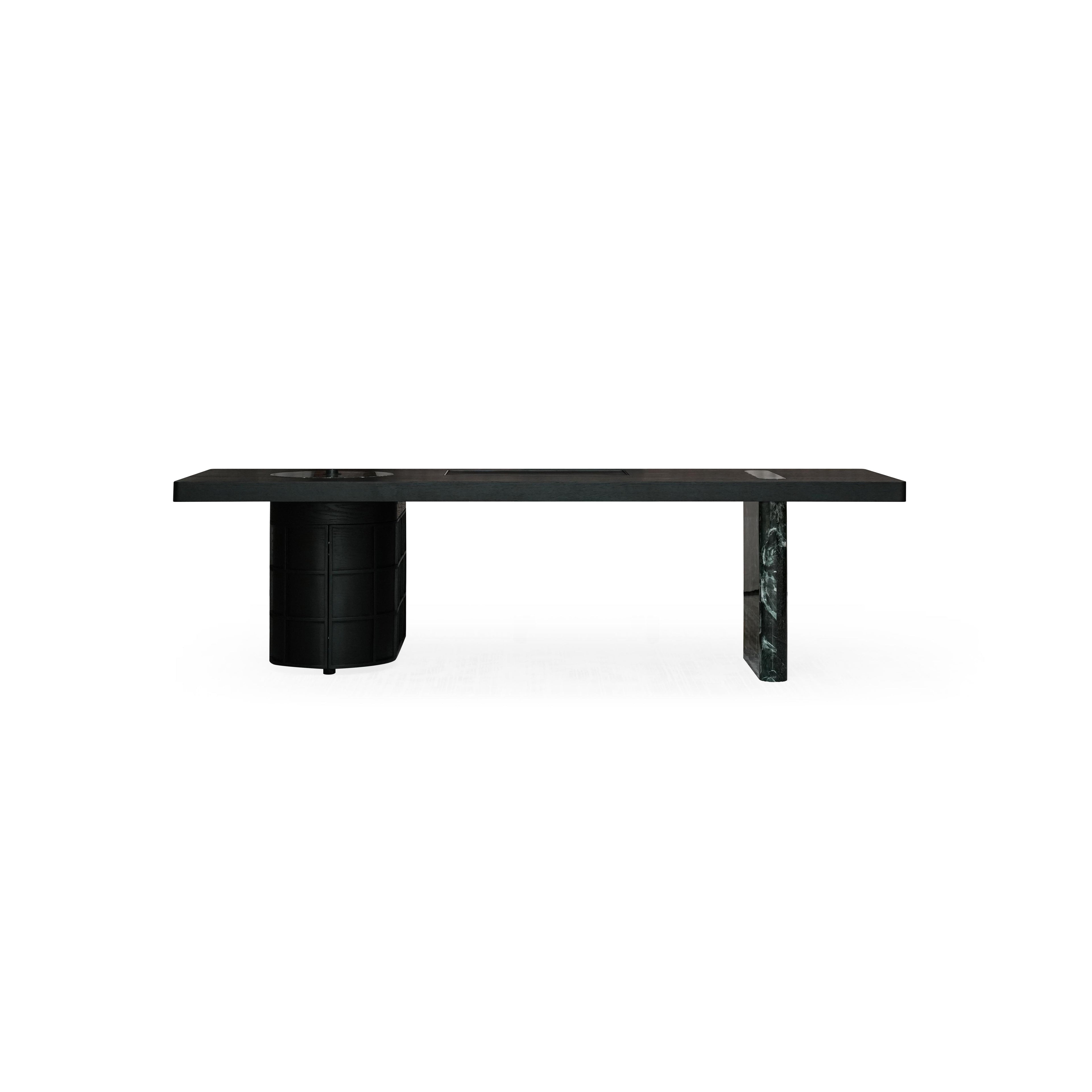 Long rectangular desk with light wood top and two distinct legs â€?one cylindrical with stacked drawers, the other solid dark stone-like material. Features three recessed cutouts on surface. Intended for work or study. Category: furniture/desks