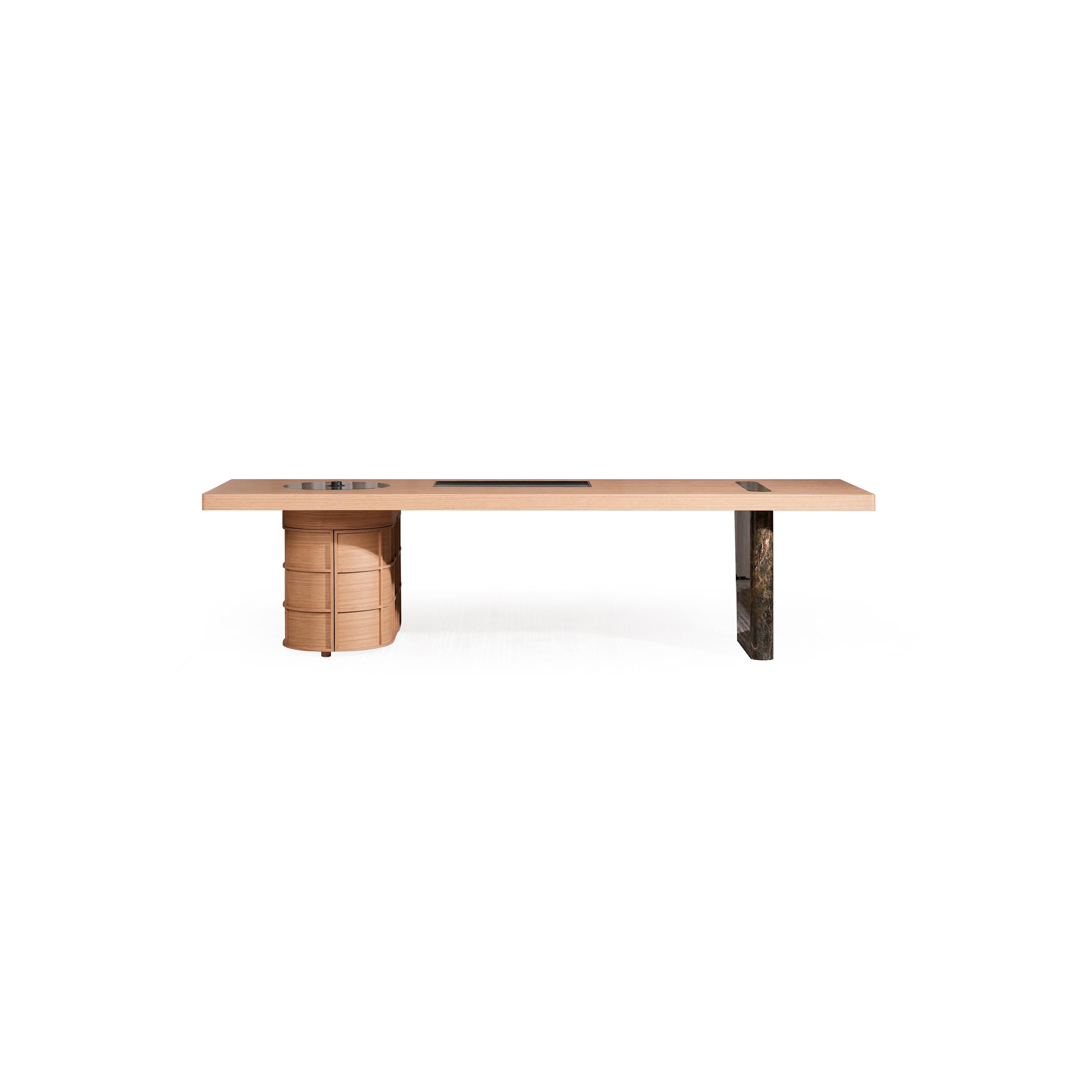 Long rectangular desk with light wood top and two distinct legs â€?one cylindrical with stacked drawers, the other solid dark stone-like material. Features three recessed cutouts on surface. Intended for work or study. Category: furniture/desks