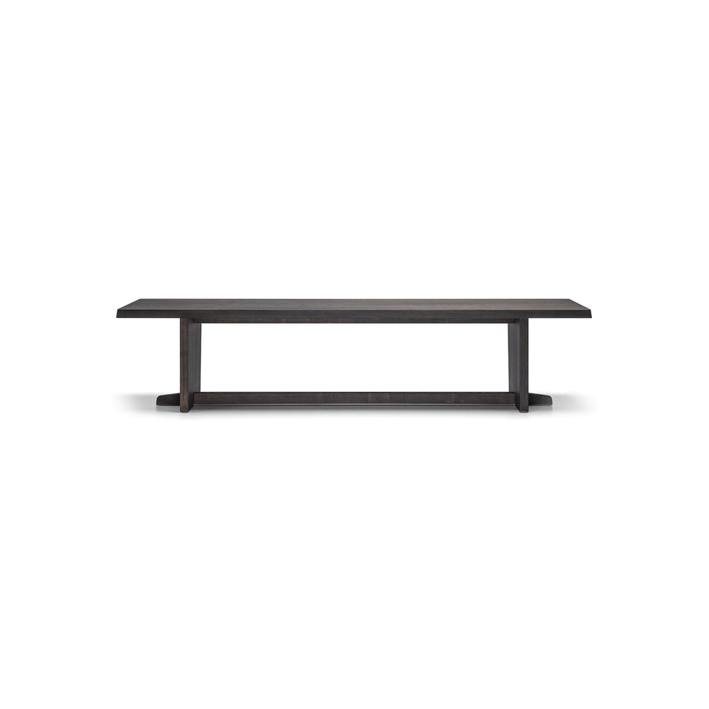 A long rectangular dining table with a dark wood finish and visible grain. It has two vertical legs connected by a horizontal stretcher bar. The tabletop is flat and smooth. Intended for dining, it features a minimalist design with no drawers or handles. Category: furniture/dining-tables